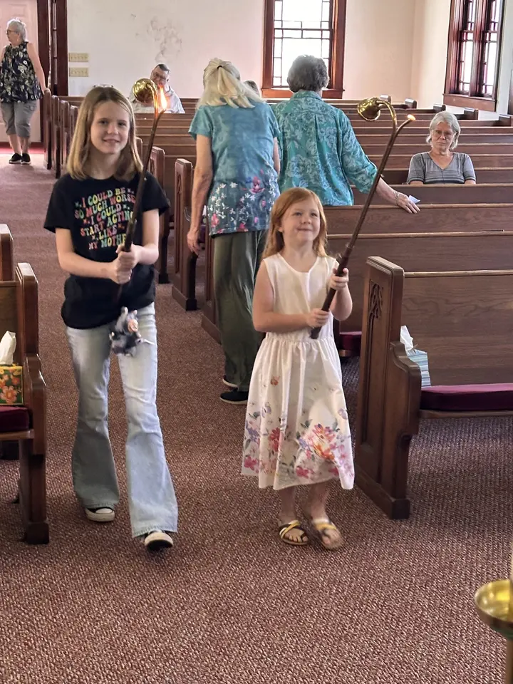 Children walking down the center aisle of the sanctuary during a service.