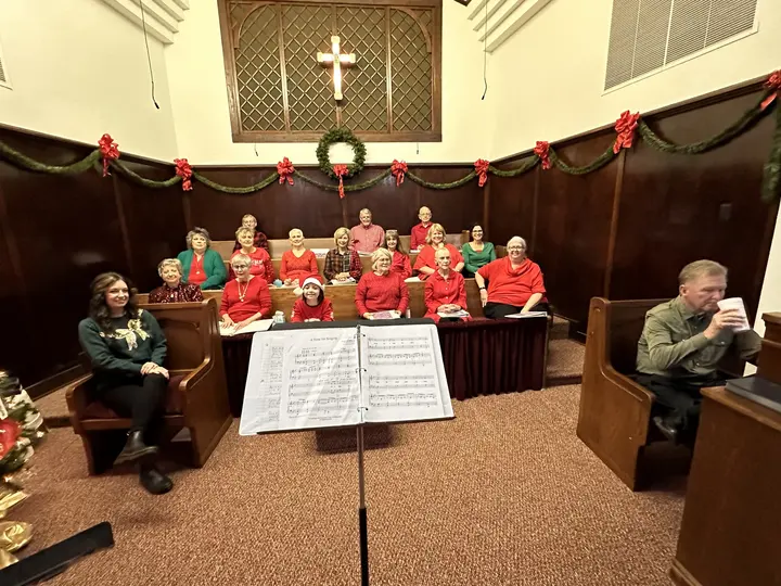 The chancel decorated for Christmas with rows of red poinsettias along the altar rail.