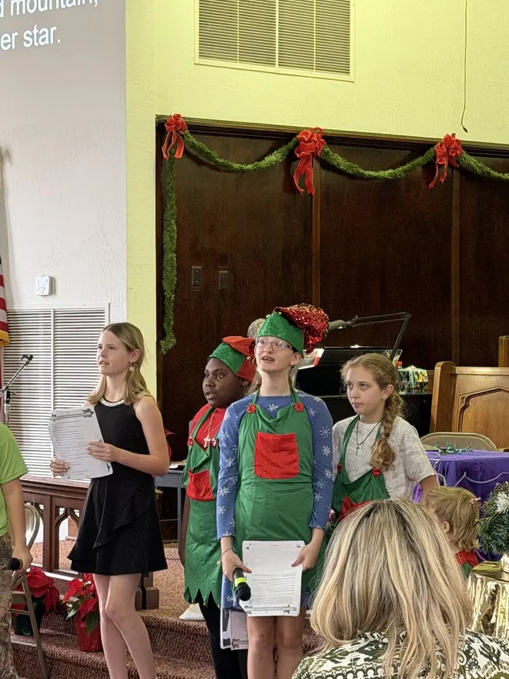 Children dressed as elves performing in the Christmas program at the front of the sanctuary.