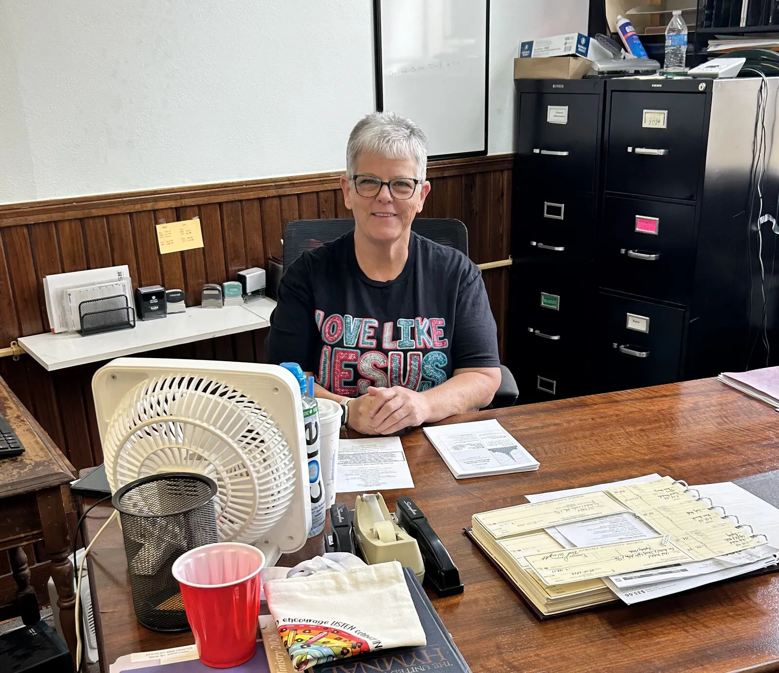 A volunteer at work at the desk in the church office.