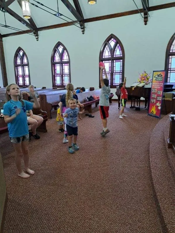 Vacation Bible School group of children and volunteers gathered outside the church.